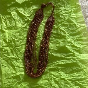 Brown multi-strand necklace with small seed beads and a long design